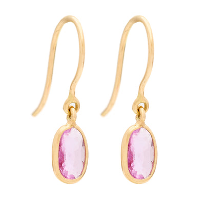Gold earrings with pink gemstones on a white background